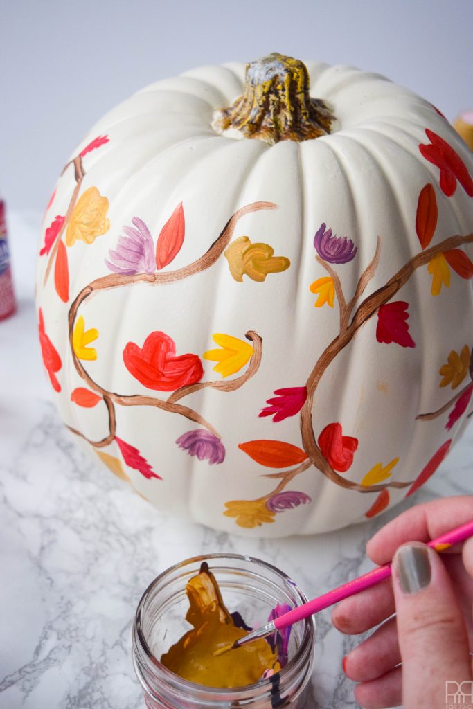 picture of painted white pumpkin with fall leaves