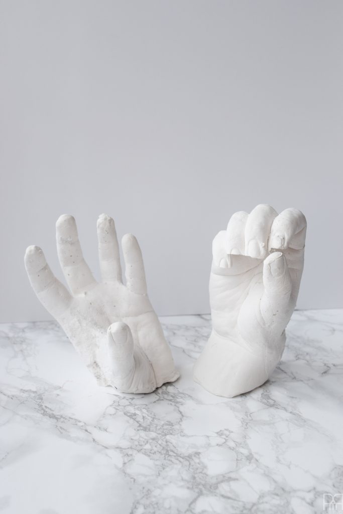 DIY Grave Robber Hands for a spooky piece of Halloween decor. Using plaster hand casts, paint, and little gemstone