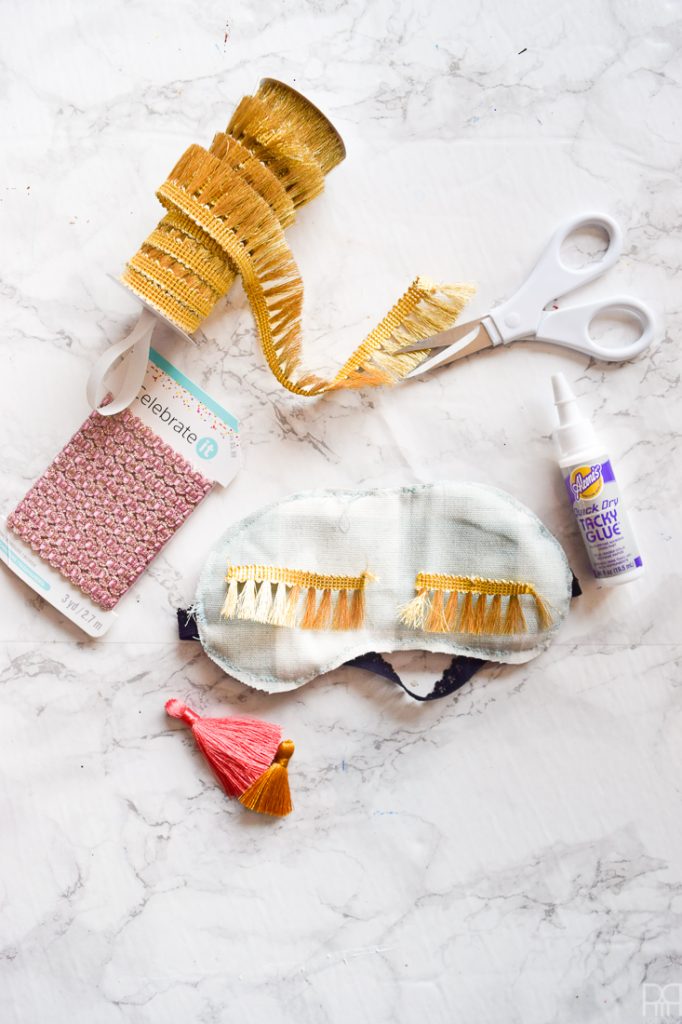 Make your own DIY Holly Golitghtly Sleep Masks with the supplies you may already have. Colourful tassels and pom poms, fringe, and fabric scraps are all you need for these fun sleep masks that would also make a great gift.