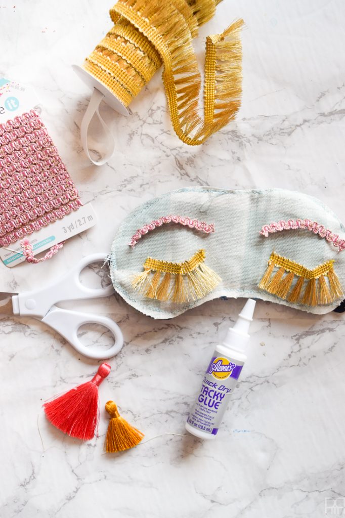 Make your own DIY Holly Golitghtly Sleep Masks with the supplies you may already have. Colourful tassels and pom poms, fringe, and fabric scraps are all you need for these fun sleep masks that would also make a great gift.