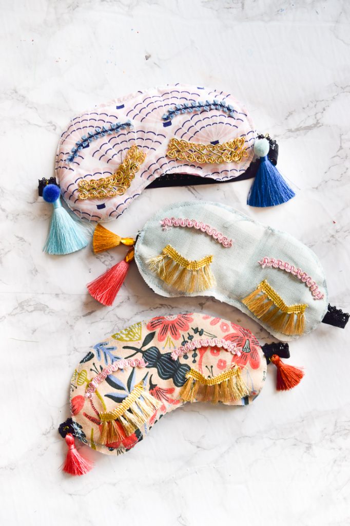 Make your own DIY Holly Golitghtly Sleep Masks with the supplies you may already have. Colourful tassels and pom poms, fringe, and fabric scraps are all you need for these fun sleep masks that would also make a great gift.