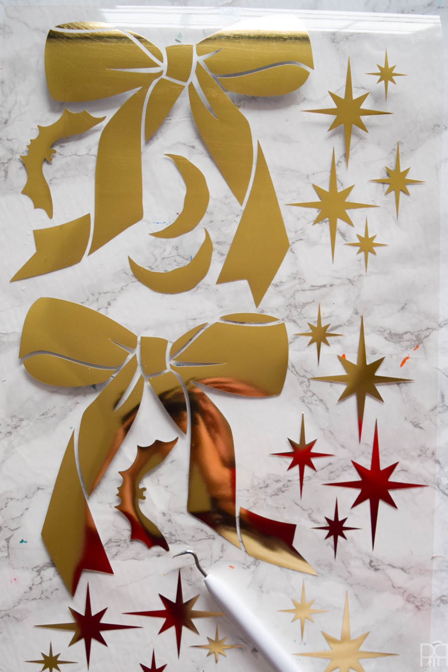 bows and atomic starbursts cut out of gold HTV against a marble background