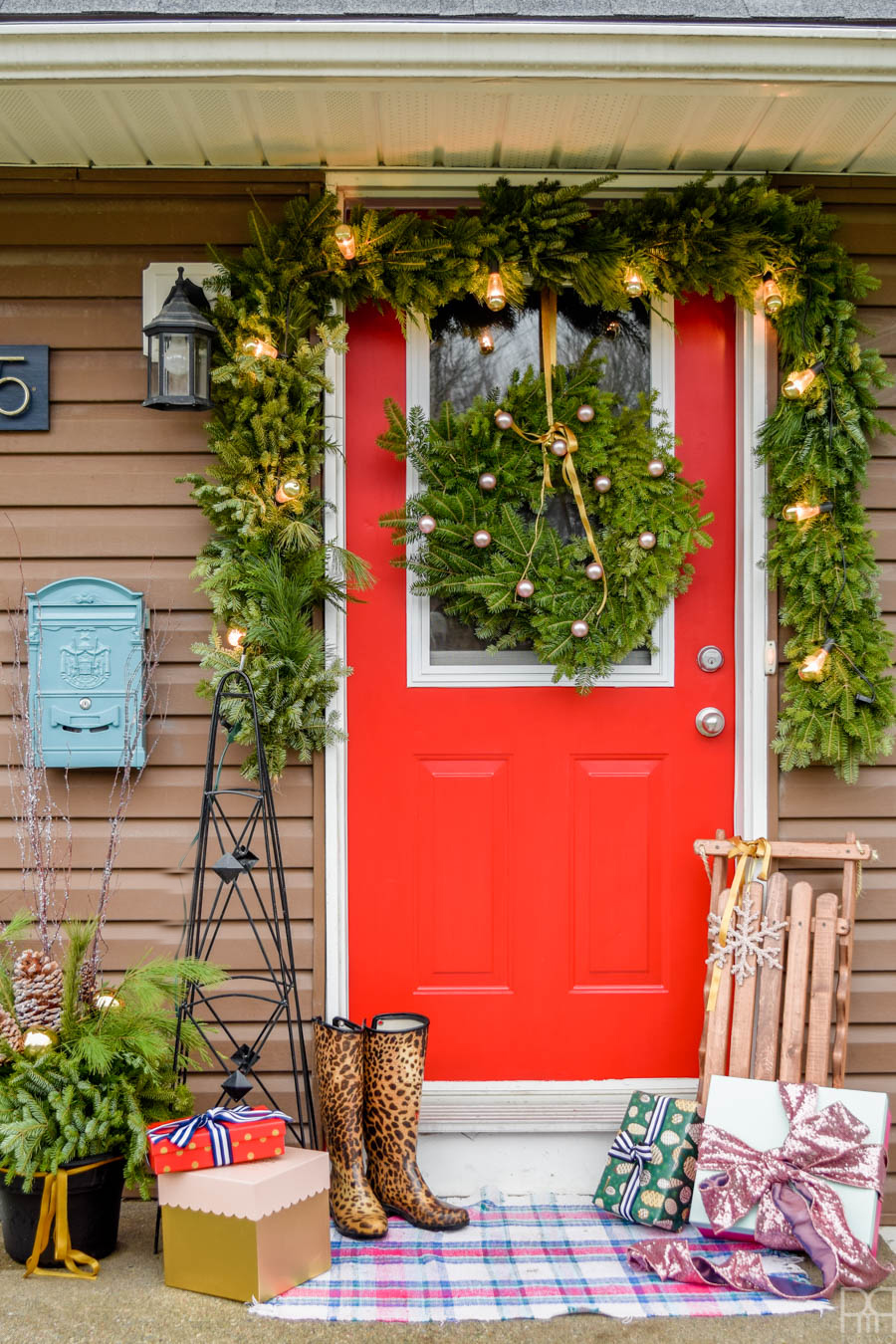 We're off to a good start over here with my colourful Christmas front porch. A bright red door and Yuletide greenery are the perfect touch. #curbappeal #christmasporch #homefortheholidays 