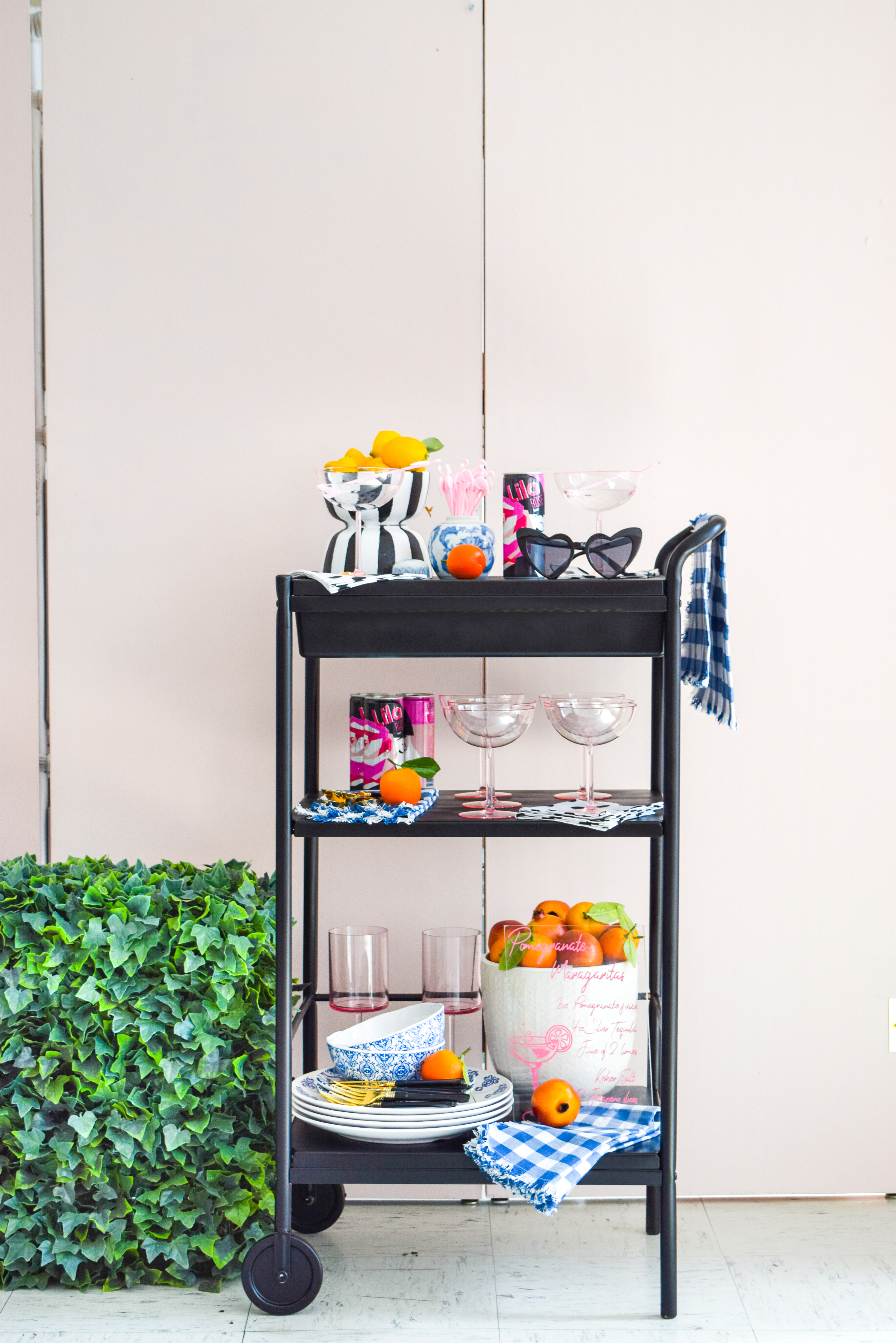 styled summer bar cart with green hedge