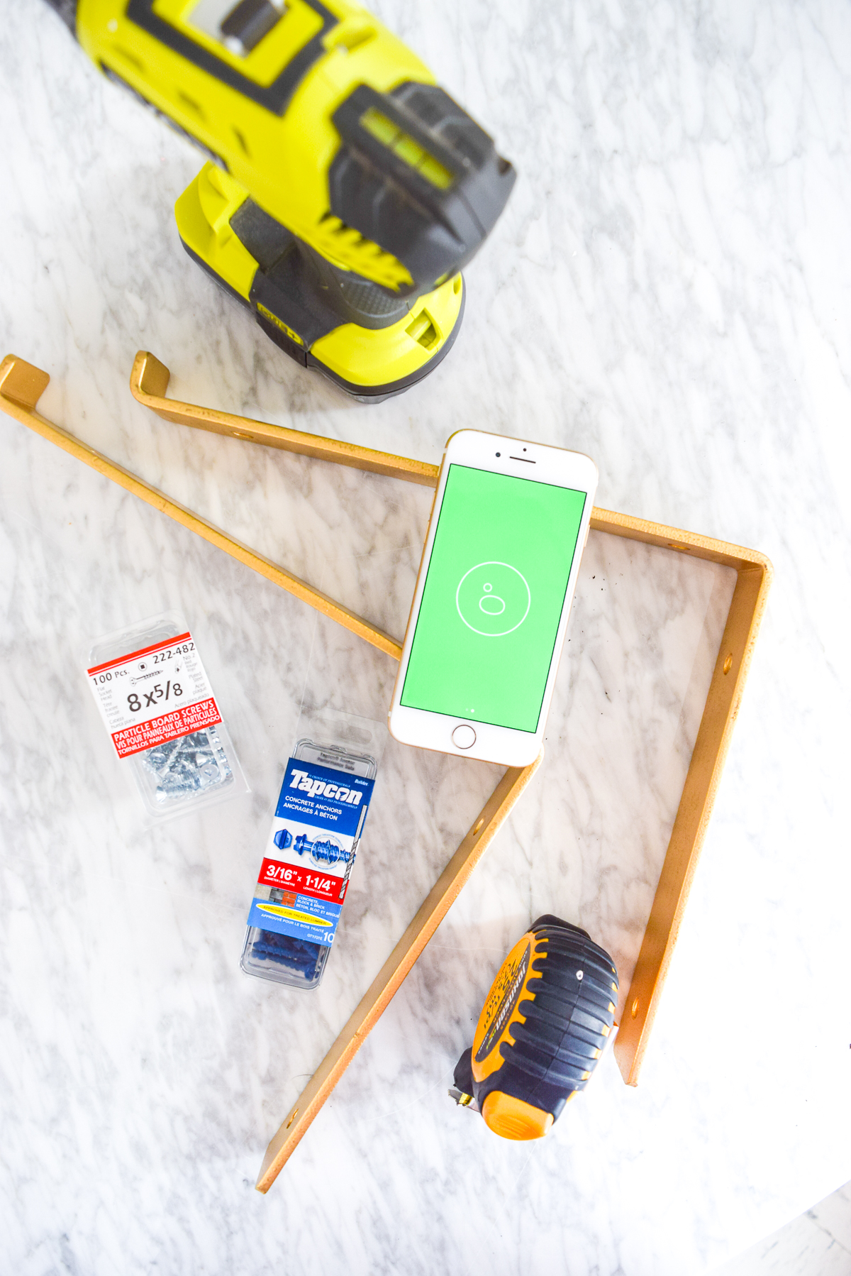 gold shelf bracket and tools on a marble table