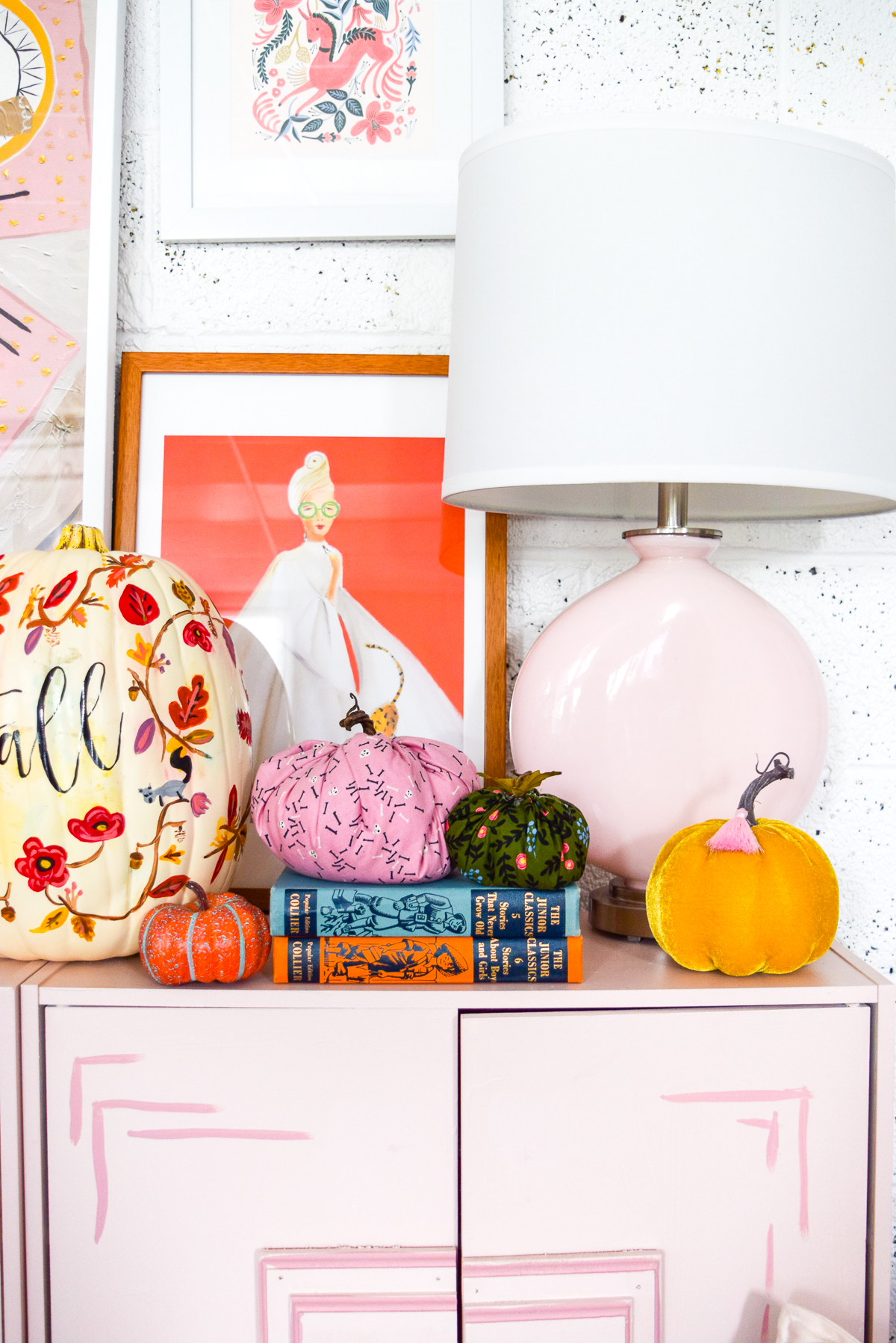pumpkins and books on a pink dresser