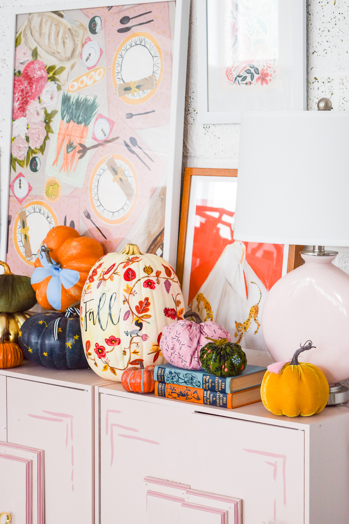 pink dresser with pumpkins and art