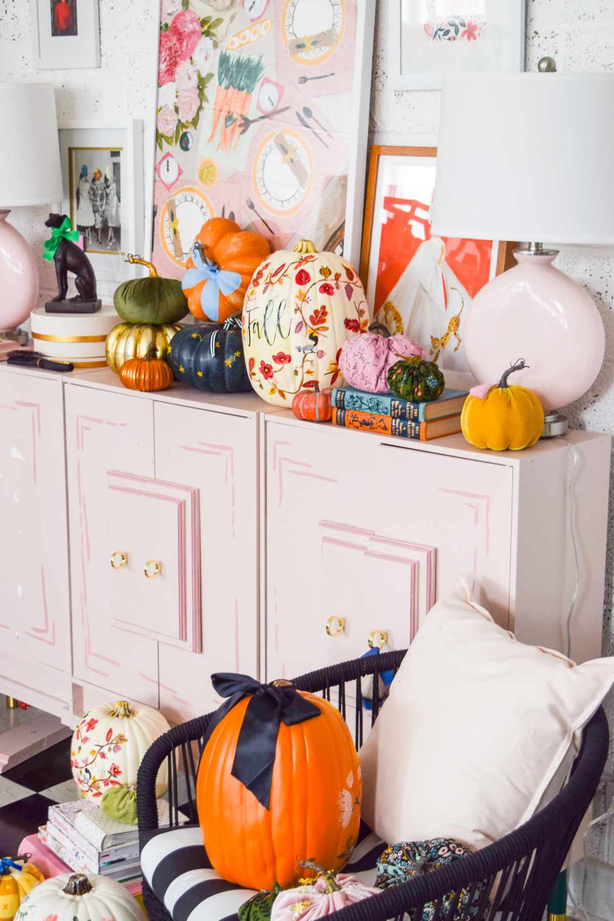 angled shot of a pink dresser with various pumpkins