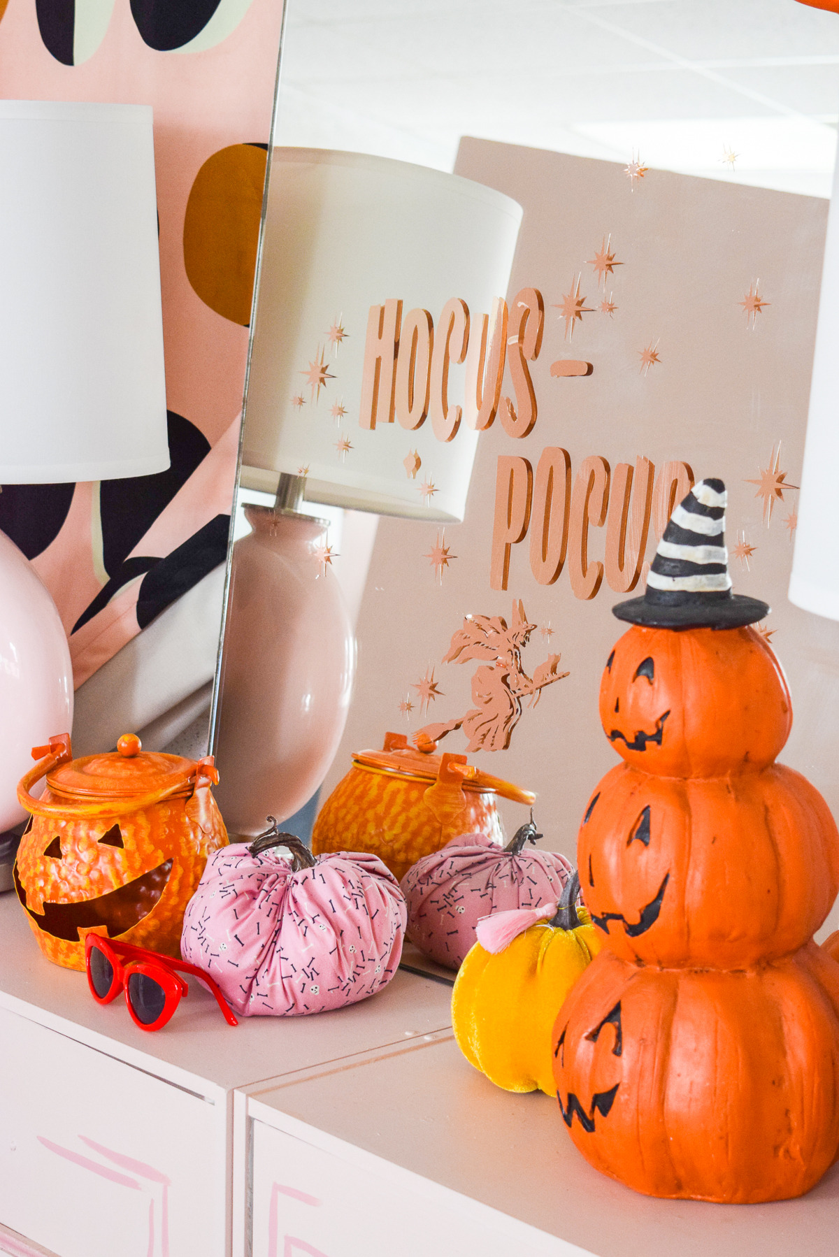 hocus pocus mirror sitting on a pink console with halloween pumpkins