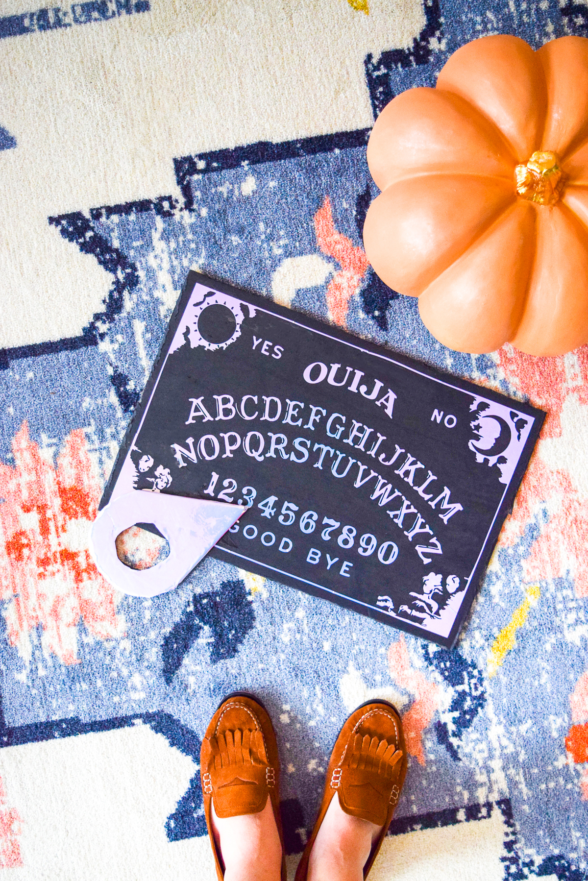 diy holographic ouija board on a carpet near a pumpkin