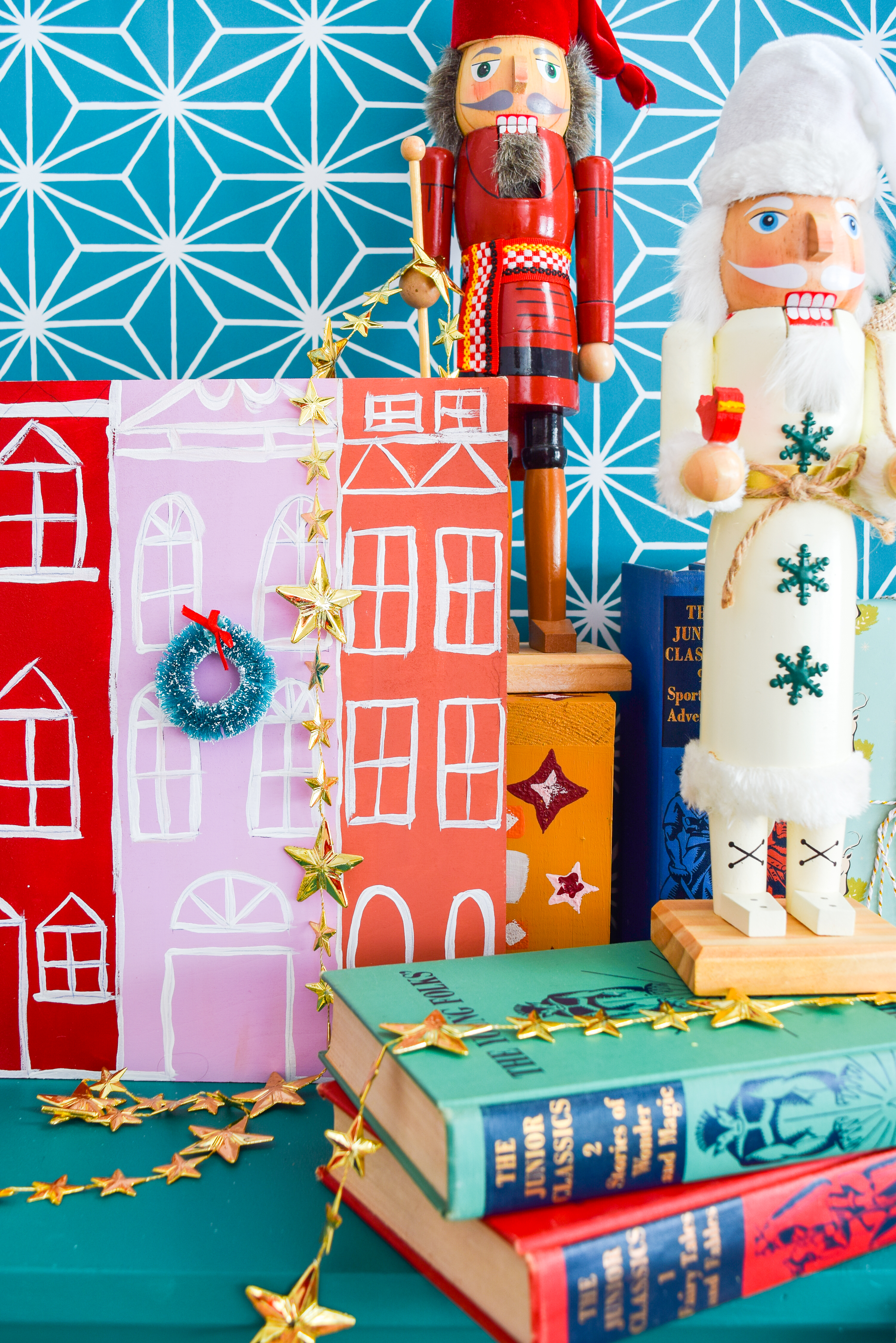 A painted Christmas village is all you need to bring a dose of seasonal cheer (and colour!) to your Christmas mantel, sideboard, or console table! Grab your Americana Acrylic Paints & Dazzling Metallics to get started. #christmascraft #christmasvillage 