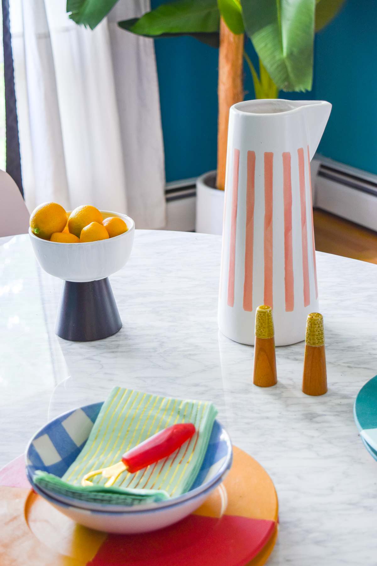 A mid century modern dining room, full of color, teak, marble, and color blocked walls. What's not to love? Come grab inspo and sources on the blog.