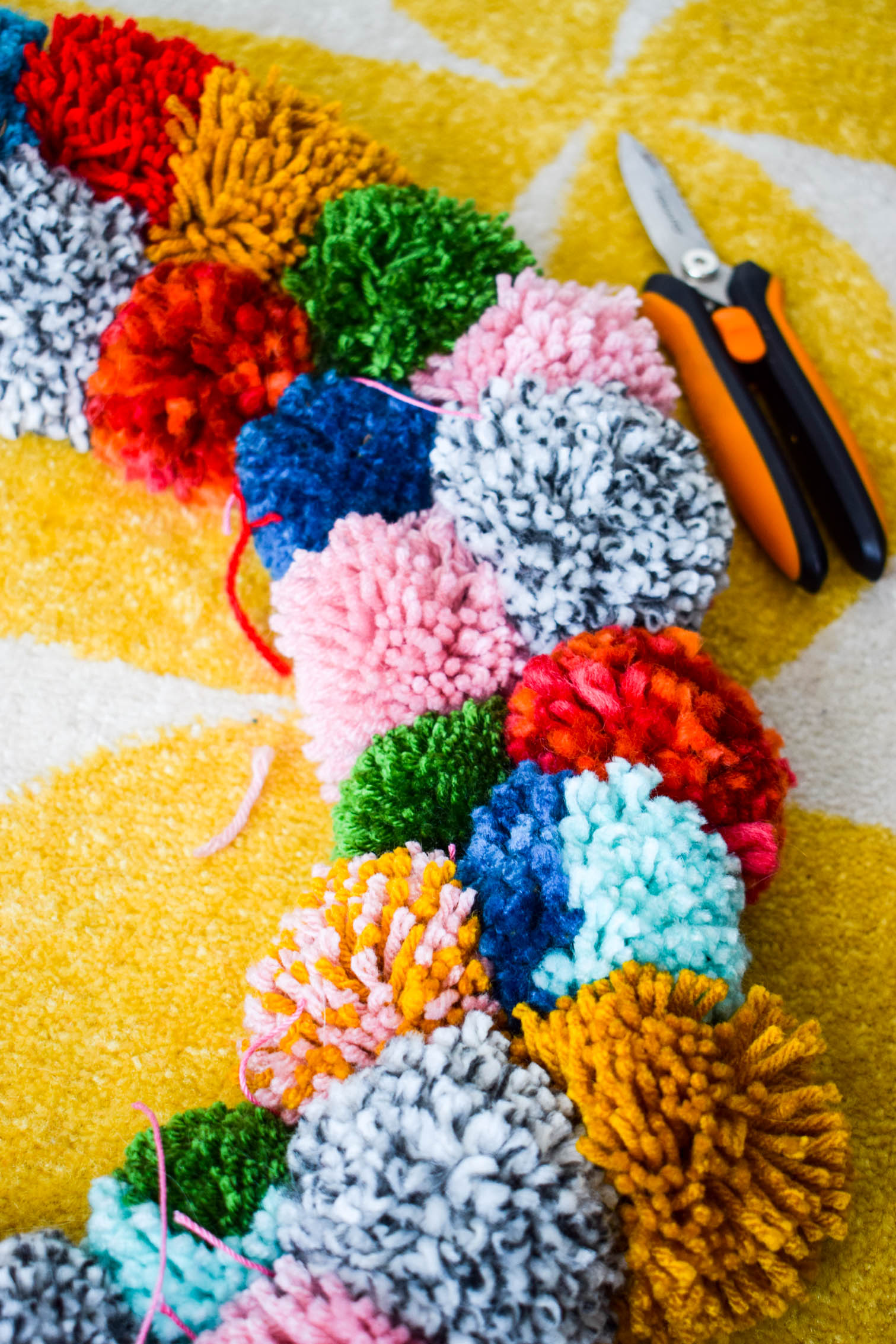 Make your own pom pom wreath this holiday season, and add a bold statement to your decor. This wreath is easy to make and a lot of fun to put together.