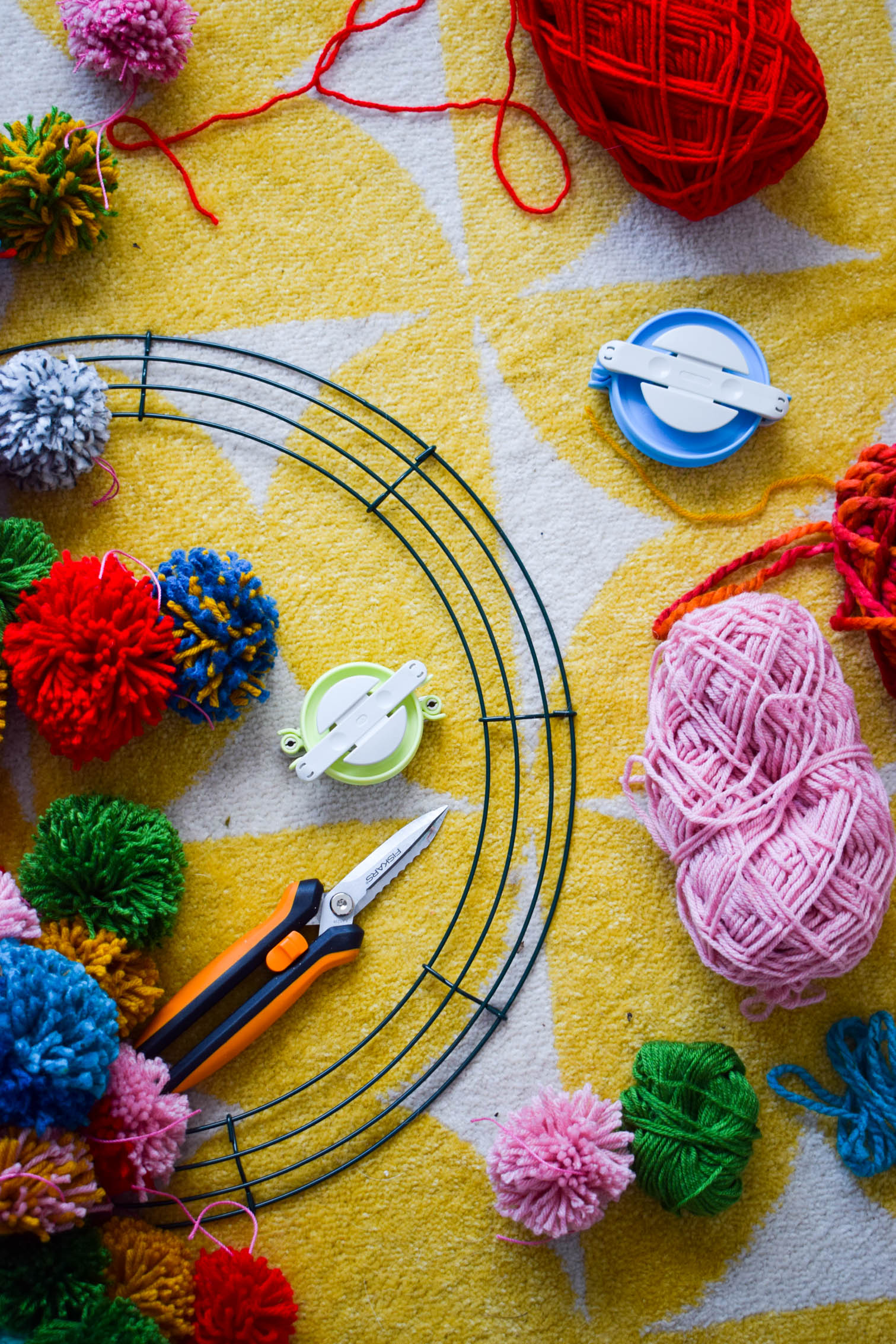 Make your own pom pom wreath this holiday season, and add a bold statement to your decor. This wreath is easy to make and a lot of fun to put together.