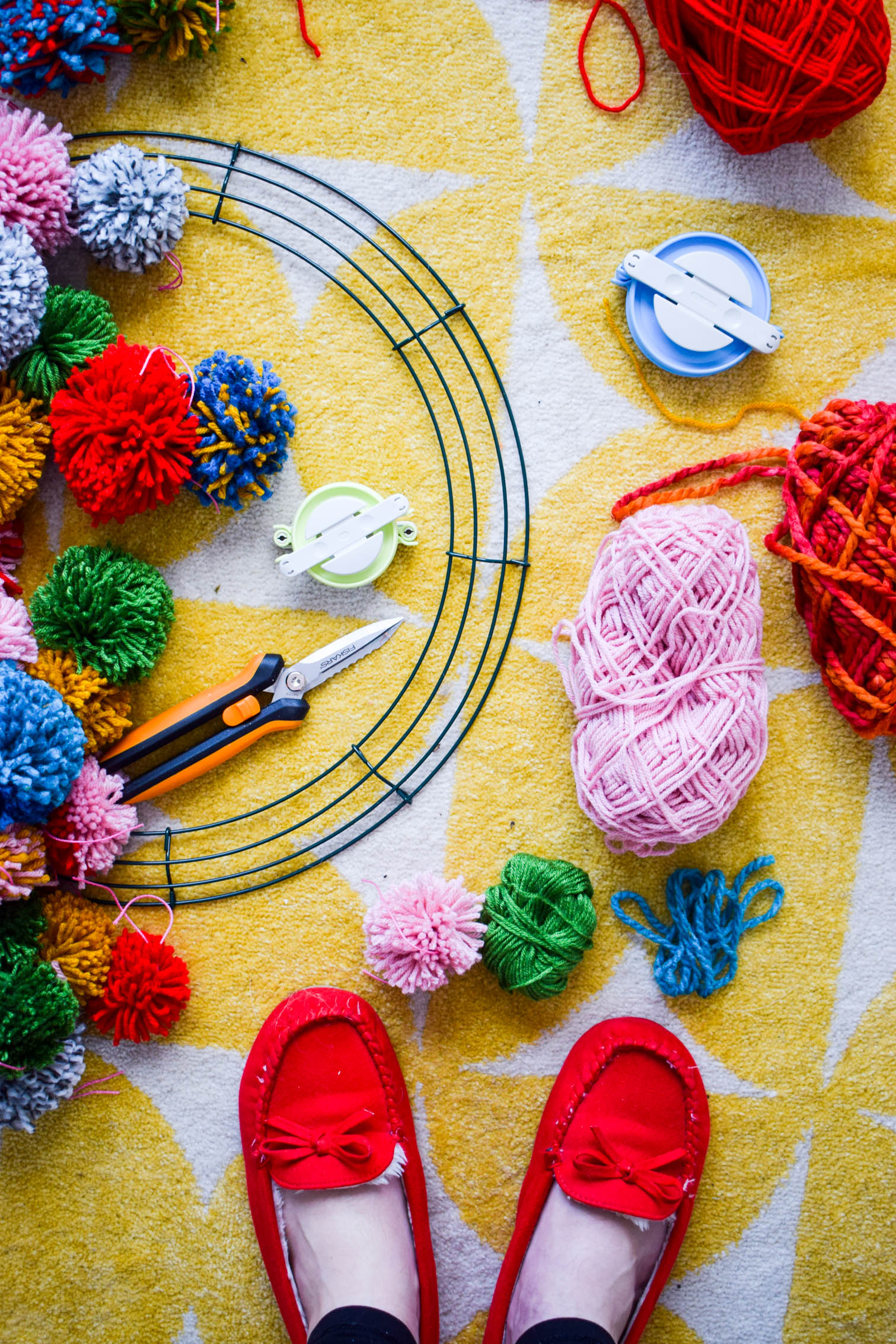 Make your own pom pom wreath this holiday season, and add a bold statement to your decor. This wreath is easy to make and a lot of fun to put together.