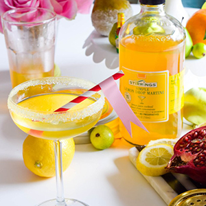 lemon drop martini shown with pink and white striped straw