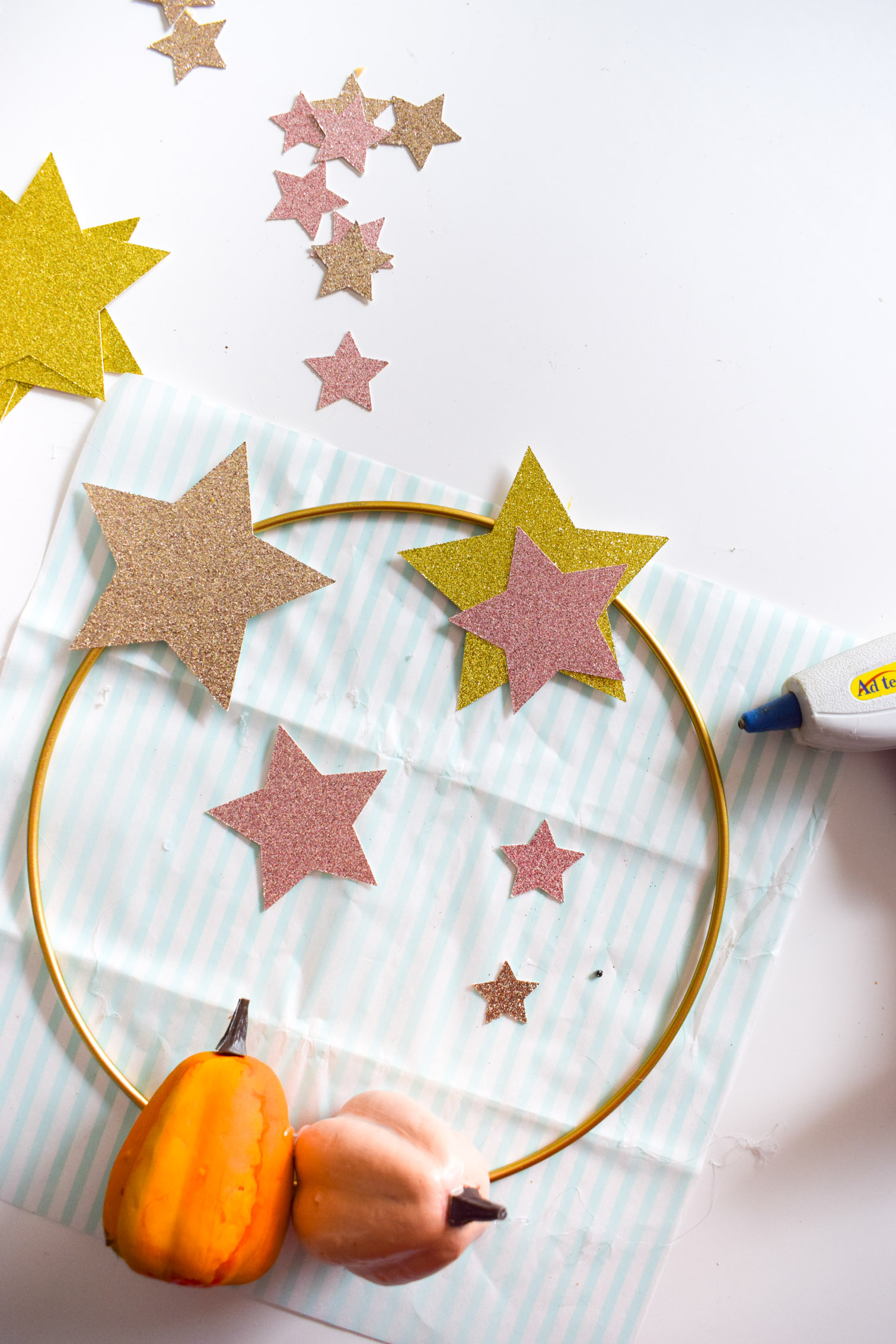 Using glitter cardstock and craft pumpkins, create a star and pumpkin fall wreath. A hoop wreath for your front door, and one for the playhouse too!